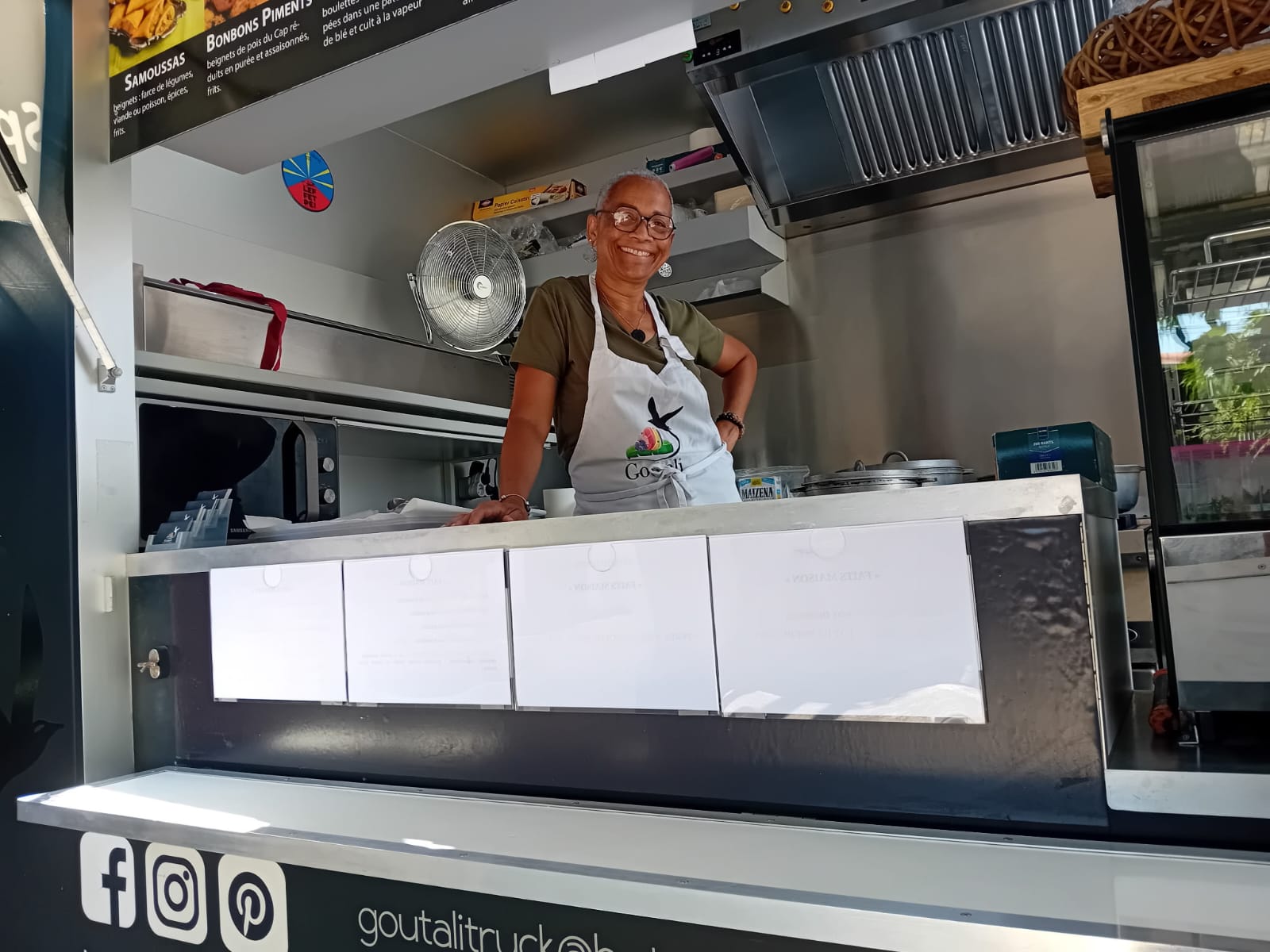 Lilia Barbe souriante au comptoir du food truck Goutali au marché de Saint-Cyprien